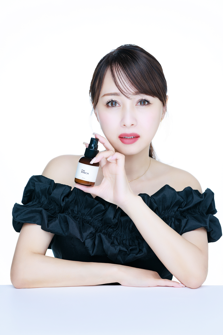 I'm PINCHの美容液ボトルを手に持つ渡辺美奈代さん